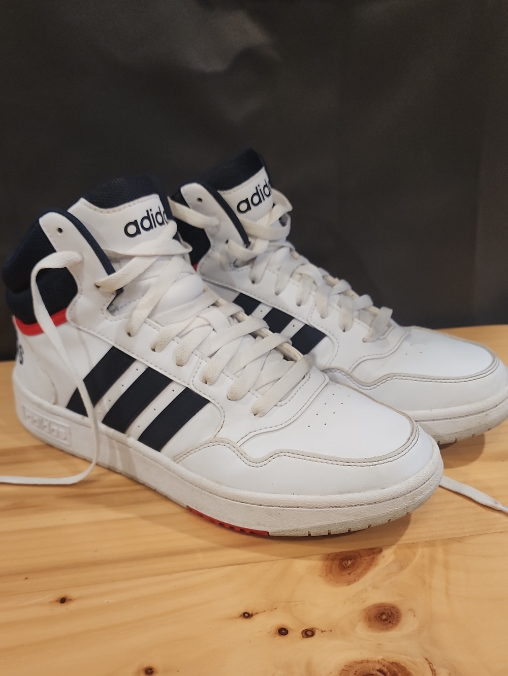 Adidas Hoops 3.0 Mid sneakers in Cloud White with Legend Ink navy blue stripes.